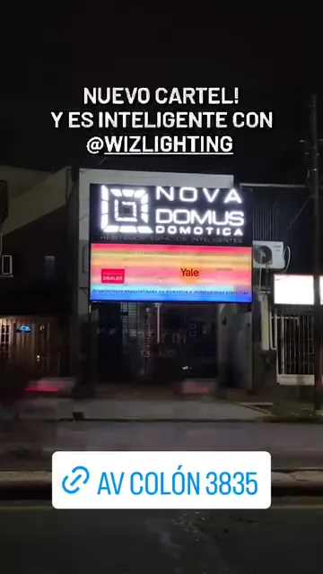 Cartel iluminado de Nova Domus sobre la fachada de Av. Colón 3835, con efecto de color RGB controlado por WiZ