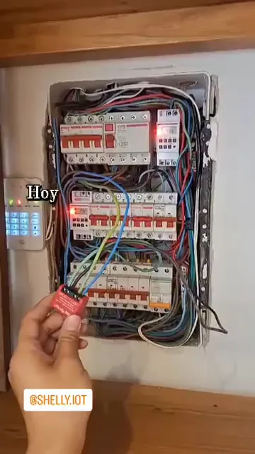 Tablero eléctrico abierto con las llaves térmicas identificadas, durante la instalación de un módulo Shelly