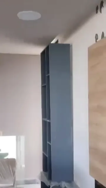 Parlante embutido en el cielorraso, con una columna de audio empotrada en el pasillo de fondo