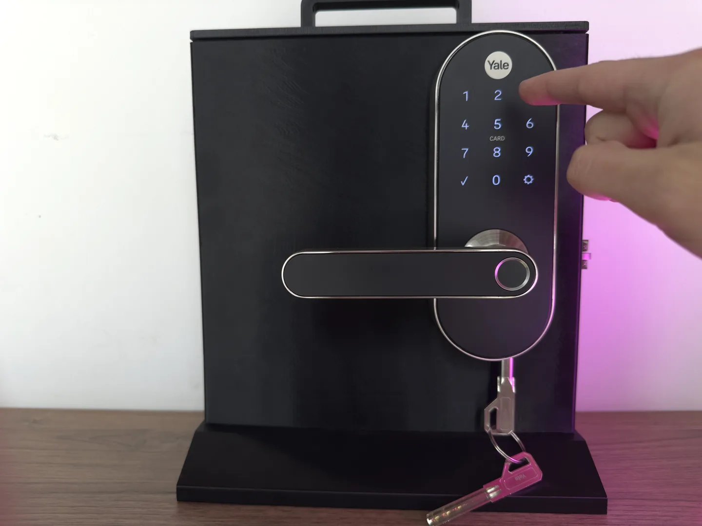 Cerradura digital instalada, con una mano marcando el código en el teclado