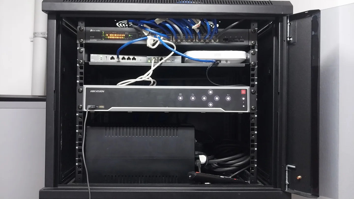 Rack de comunicaciones abierto con switch, grabador de video y UPS