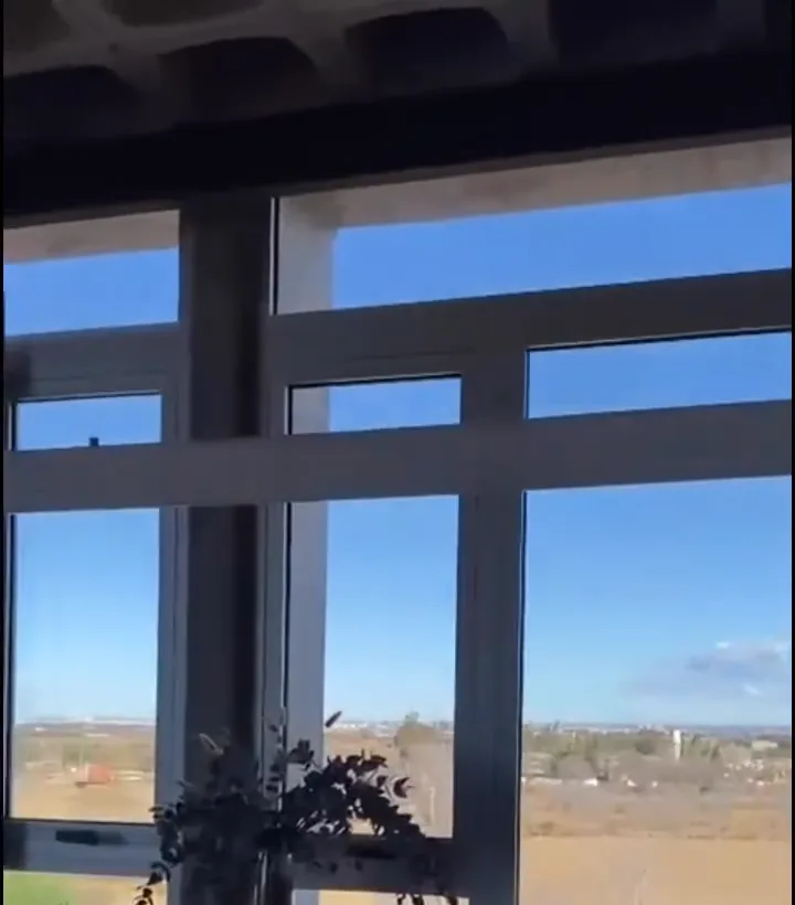 Ventanales de piso a techo con vista panorámica al campo desde un piso alto, cielorraso artesonado