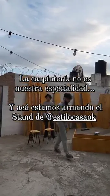 Dos integrantes de Nova Domus armando el stand para Expo Estilo Casa 2024, en una terraza al atardecer