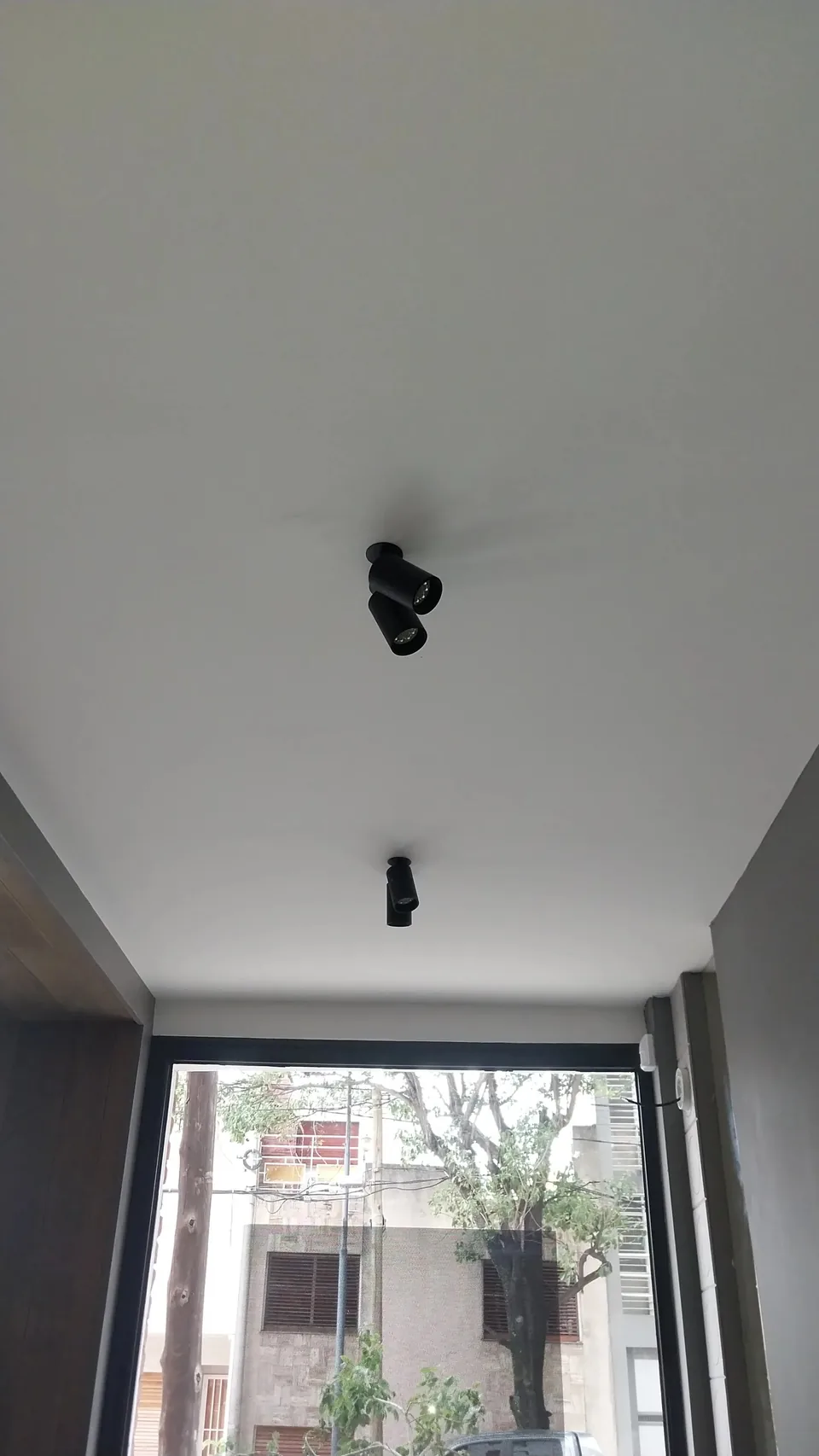 Sensores de movimiento de alarma instalados en la unión de dos paredes de un ambiente con ventanal