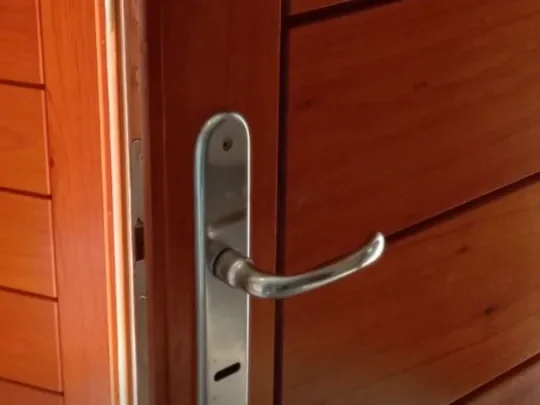 Puerta de madera con la cerradura original de picaporte y bocallave, antes de la intervención
