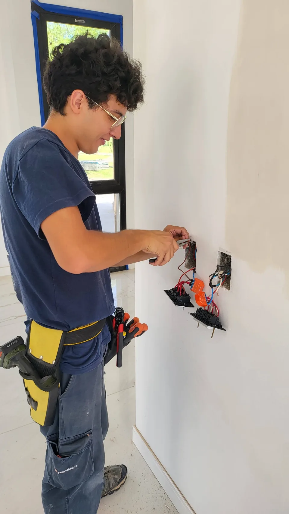 Electricista instalando una toma de pared durante una obra en construcción